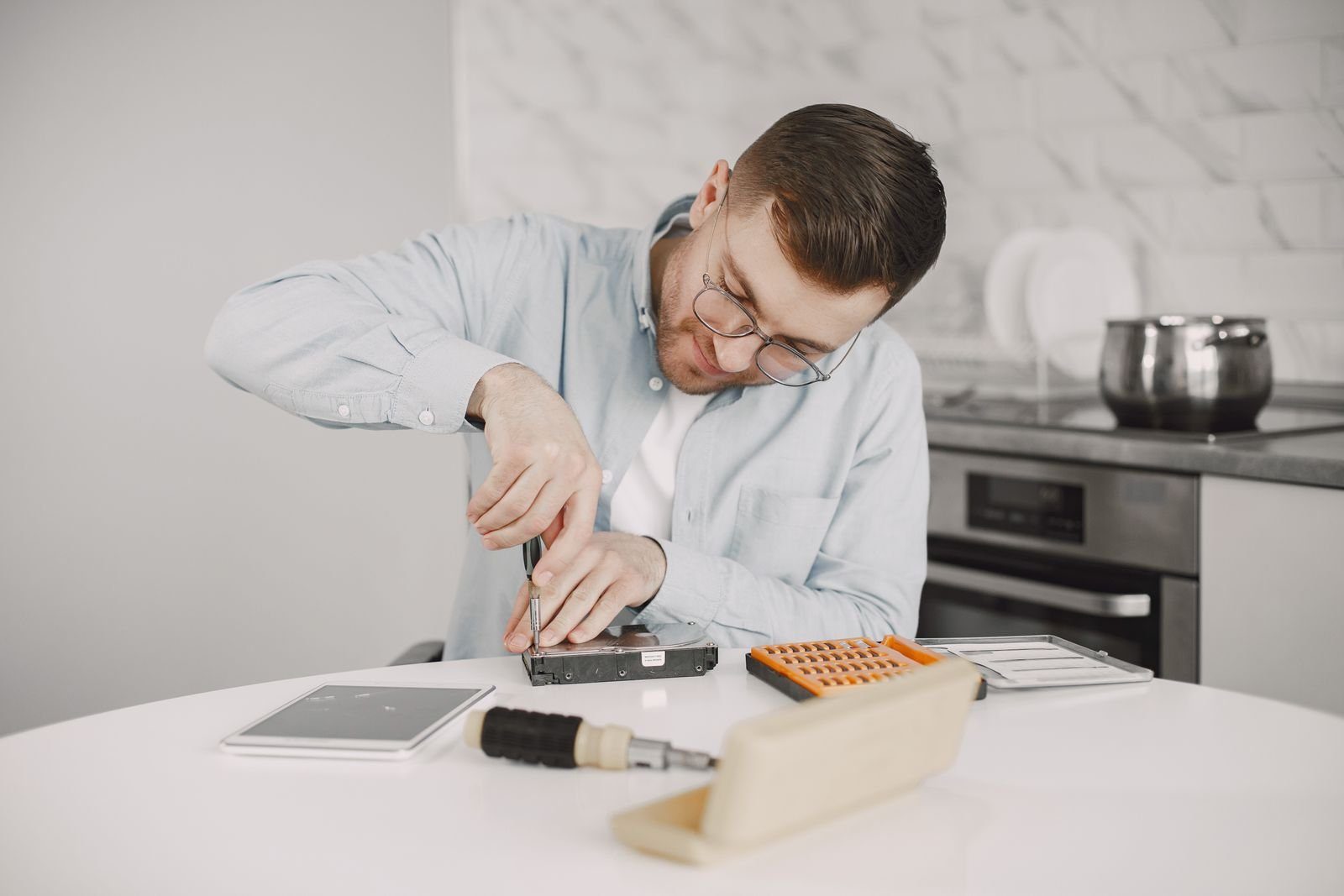 Technician repairing a small appliance at a kitchen counter